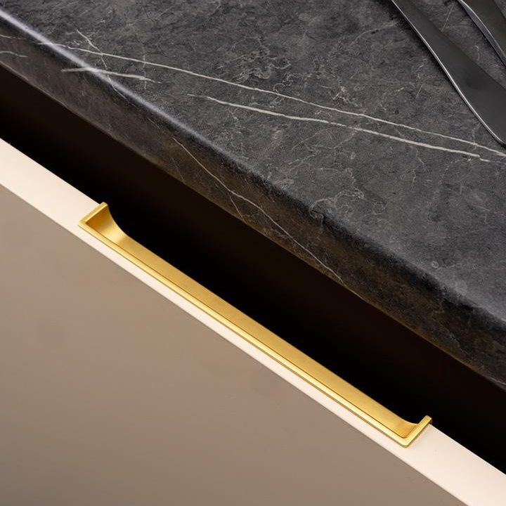 HIDE Einlassgriff aus Zamak mit minimalistischem integriertem Design an einer modernen Schubladenfront montiert.