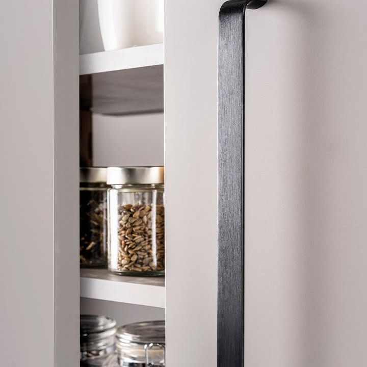 SENSE Aluminiumgriff mit schlankem, leicht geschwungenem Profil, horizontal an einer modernen Möbelschublade montiert.