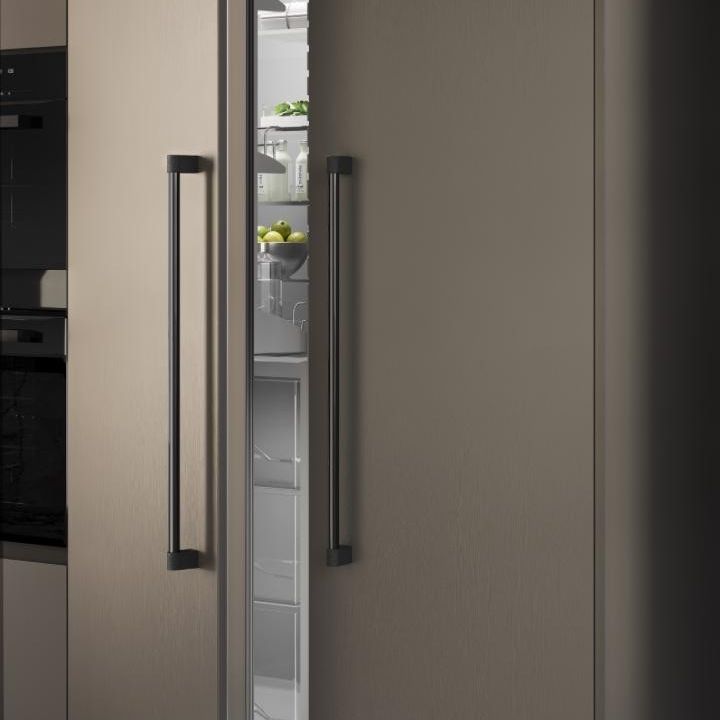 CASEY BIG Aluminiumgriff mit zylindrischem Industrial-Design und strukturierter Basis an einer modernen Möbeltür.